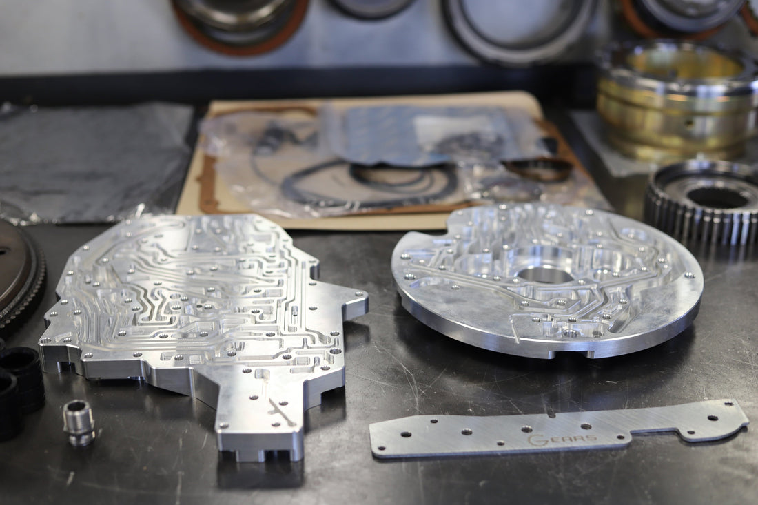 up close metallic billet transmission components on shop table